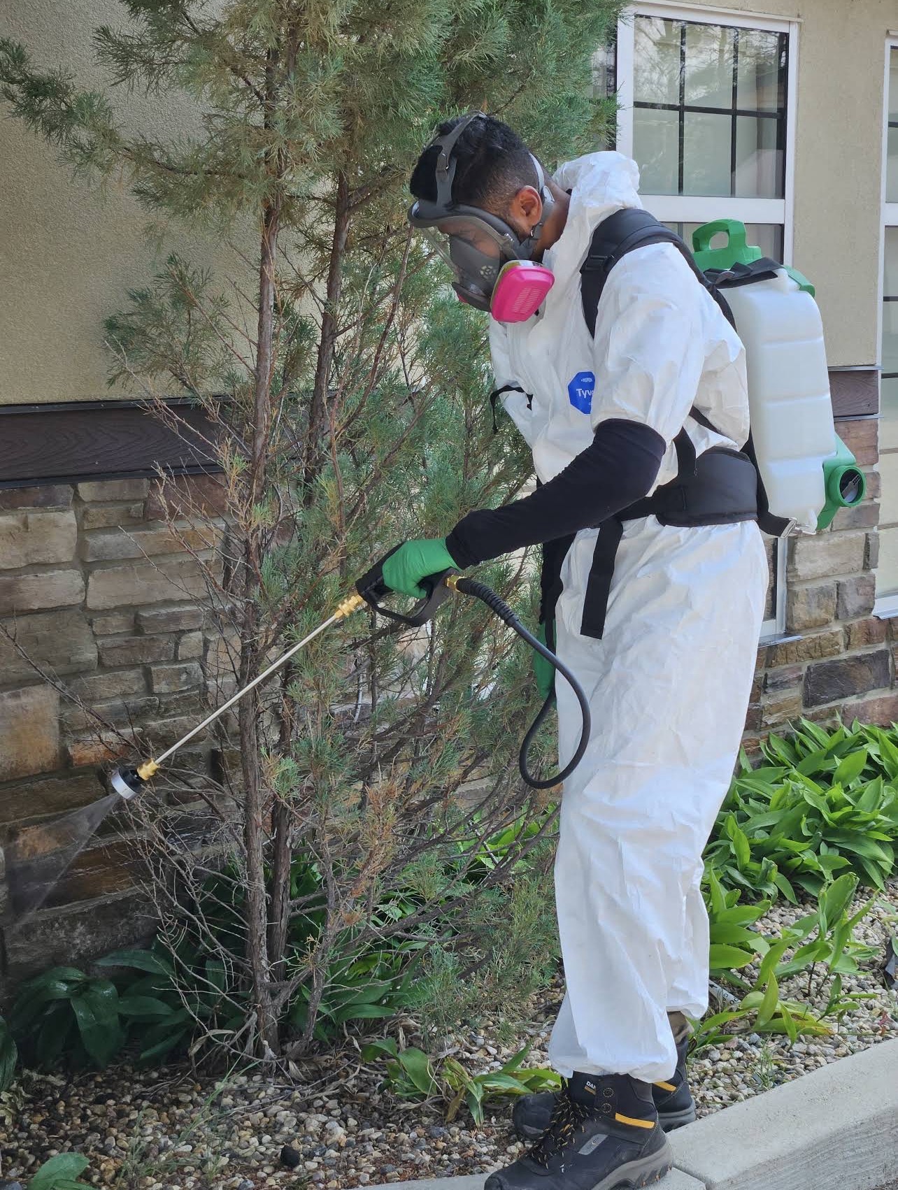 Property care technician treating landscaping at a local business
